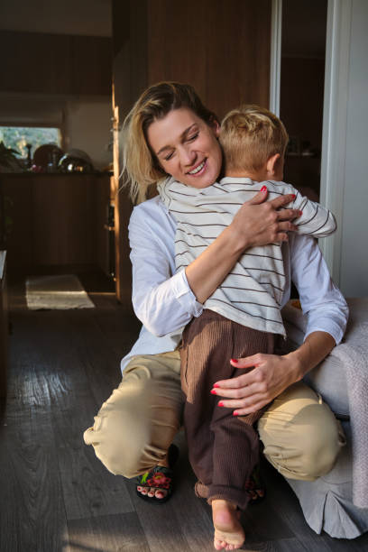 istock Mother embracing son in cozy room 1612053019