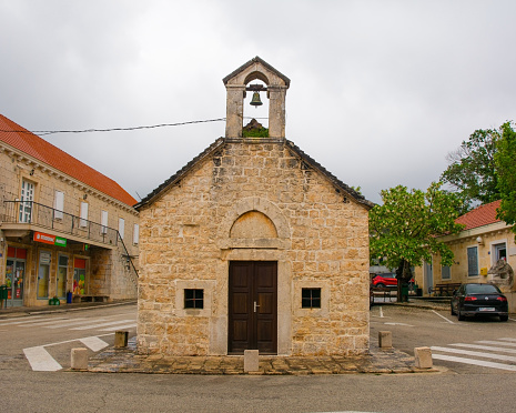 Nerezisca, Croatia - May 14th 2023. The front of the Church of Saints Michael, Peter and Paul in Nerezisca, Brac Island, Croatia. Famous for The Brac Bonsai Tree, a Dalmatian black pine growing out of its back roof