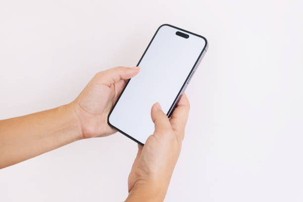 istock Female hands holding mobile phone with white screen on white background. Blank with copy space 1612159234