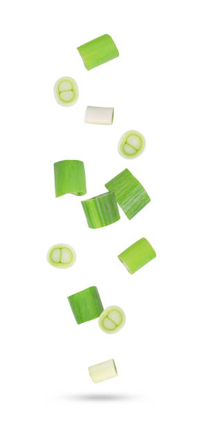 istock Green japanese onion falling in the air isolated on white 1612203015