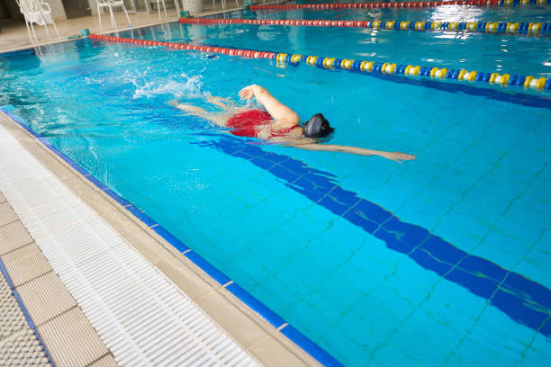 istock Athletic woman swimming front crawl in pool 1612216083