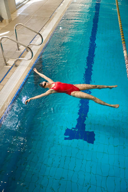 istock Professional sportswoman performing starfish float in pool 1612216612