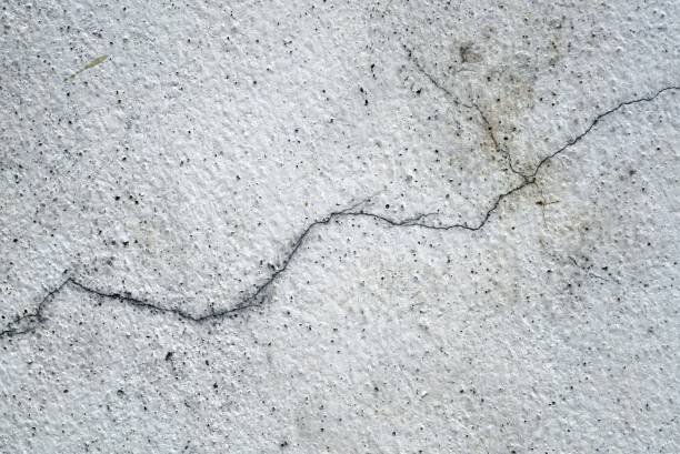 istock A cracks on the old vintage white concrete wall, abstract background and texture for design. 1612225848