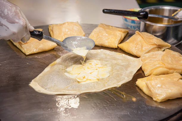 istock The process of making crepes crispy roti on a frying pan in a restaurant 1612237821
