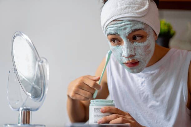 istock Young teenager applying a face mask while looking in the mirror. 1612251440