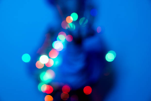 Young woman with lights in her hand, neon lighting background