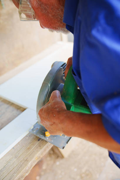 istock an elderly man in goggles with a circular saw 1612293701