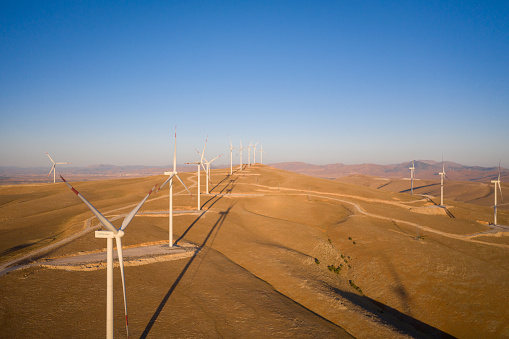 Aerial view of three wind turbines in the early morning