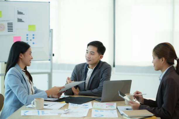 istock Group of business people sitting around a table and talking. 1612302075