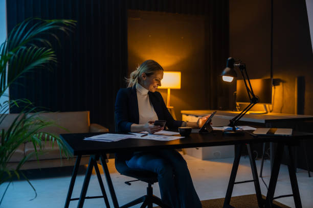 istock Happy female entrepreneur working on digital tablet till late 1612316305