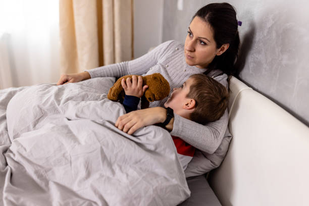 istock A happy kid is enjoying time with his mother in bed. 1612336369