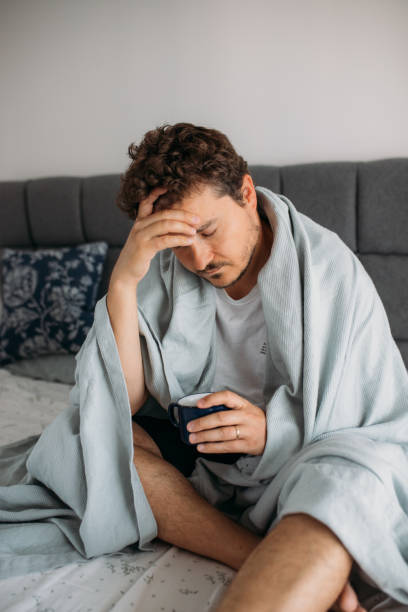 istock desperate man sitting on the bed and struggles with depression 1612342894