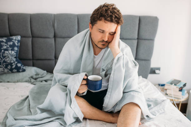 istock desperate man sitting on the bed and struggles with depression 1612343443