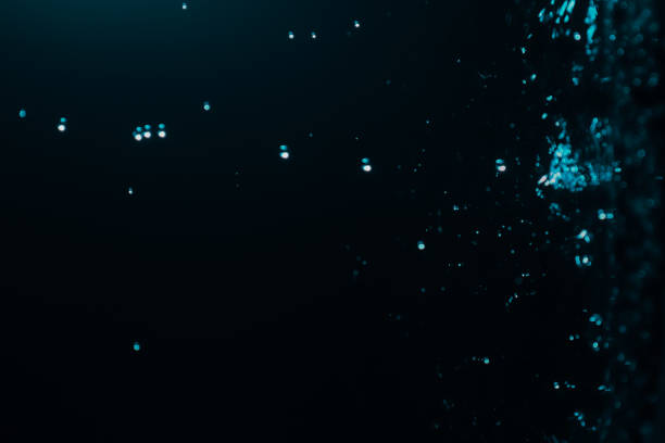 istock Blur abstract background with bokeh defocused lights and shadow. Dark water drops background. Trendy abstract nature background. 1612384940