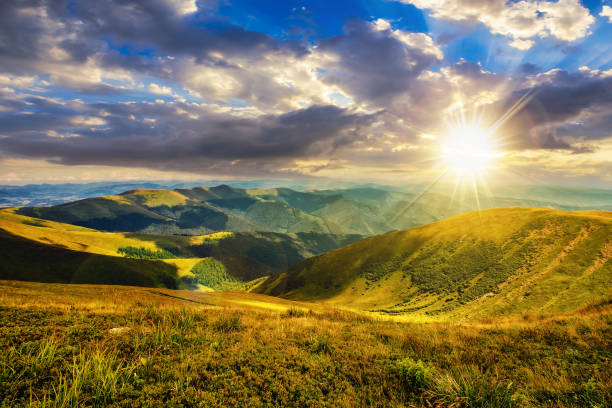 istock green grass on rolling hillside meadow in high mountains under the cloudy blue sky at sunset 1612399903
