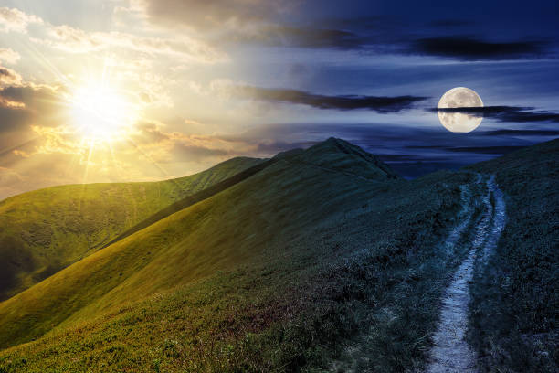istock mountain landscape with sun and moon at twilight 1612400423