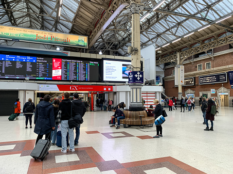 View of hall of Victoria train station, terminal station is a central London railway terminus and connected London Underground station in Victoria, in the City of Westminster, managed by Network Rail. Modern building. Lots of passengers inside of hall. Public transportation. Gatwick Express trains run direct to Gatwick