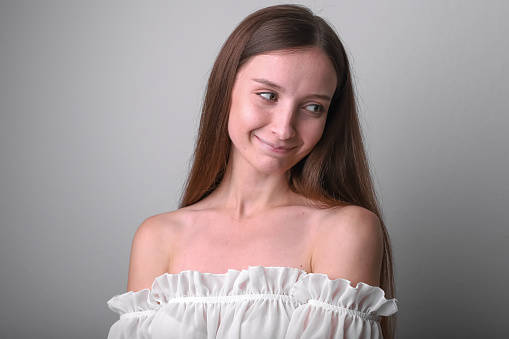 Natural Slavic beauty: Young girl with loose hair against solid backdrop