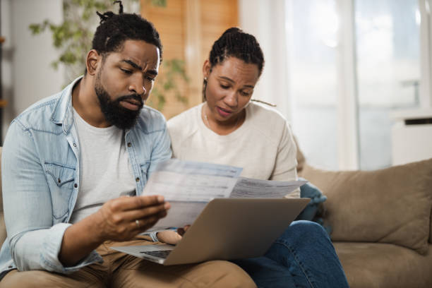 istock Young displeased black  couple having problems with financial bills at home 1612462688