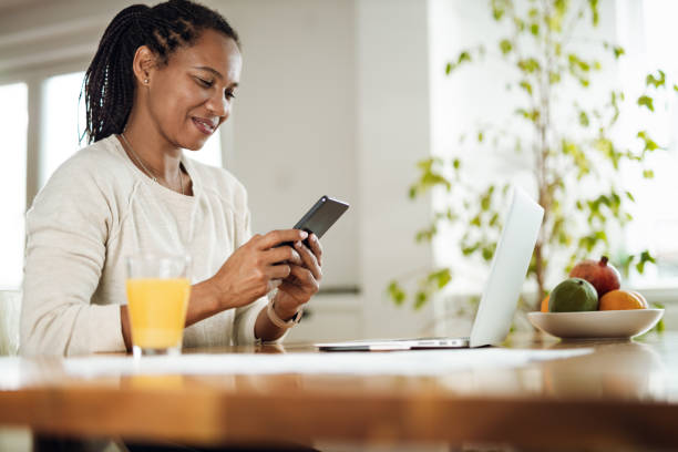 istock Happy African American woman using a phone while working at home 1612463695