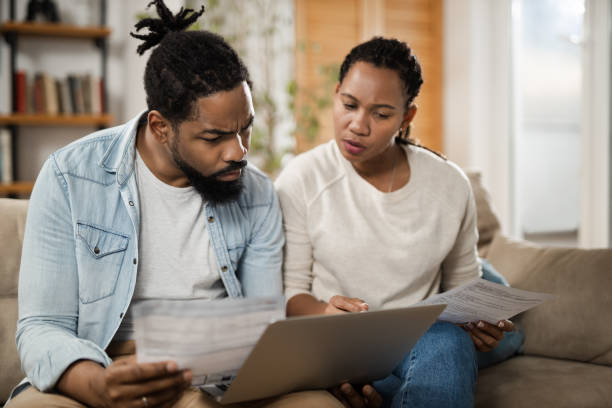 Young black couple paying their bills over laptop at home