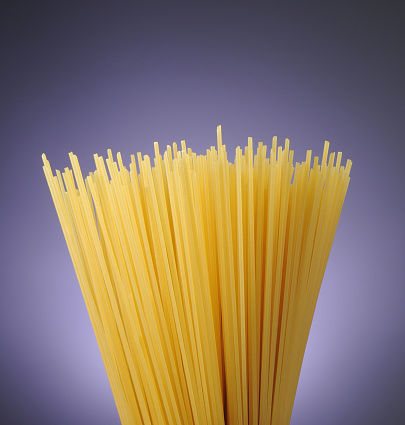 Spaghetti on purple background, studio shot