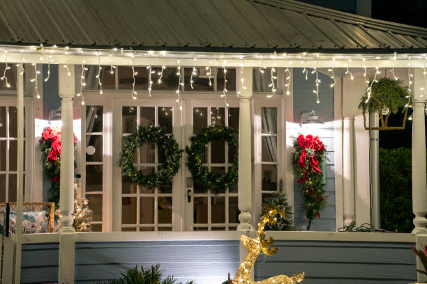 istock House front yard with big porch brightly illuminated with christmas decorations. Outside decor of florida family home for winter holidays 1612632408