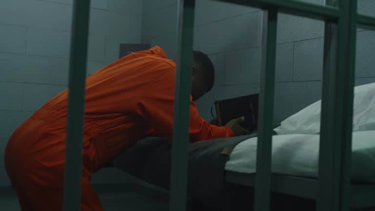 African American prisoner prays to God in prison cell