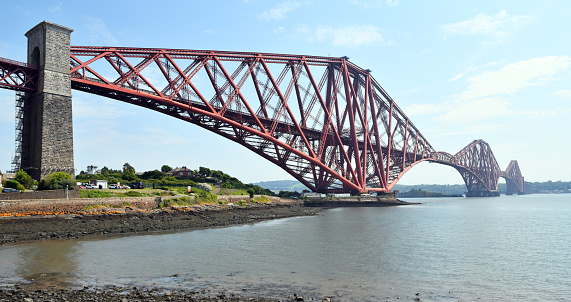 The Forth Bridge is a cantilever railway bridge across the Firth of Forth in the east of Scotland, 9 miles (14 kilometres) west of central Edinburgh. Completed in 1890, it is considered a symbol of Scotland (having been voted Scotland's greatest man-made wonder in 2016), and is a UNESCO World Heritage Site. It was designed by English engineers Sir John Fowler and Sir Benjamin Baker. It is sometimes referred to as the Forth Rail Bridge (to distinguish it from the adjacent Forth Road Bridge), although this has never been its official name.