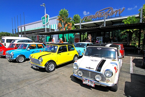 Bangkok, Thailand – January 31, 2023: An array of vintage Mini Austin Coopers in a variety of colors are parked along the side of a street