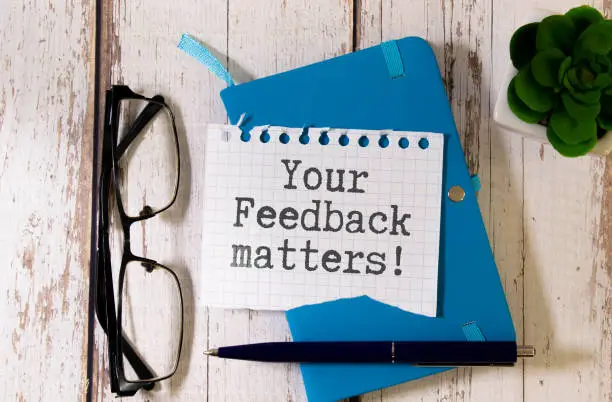 Photo of text Your Feedback matters on white torn paper