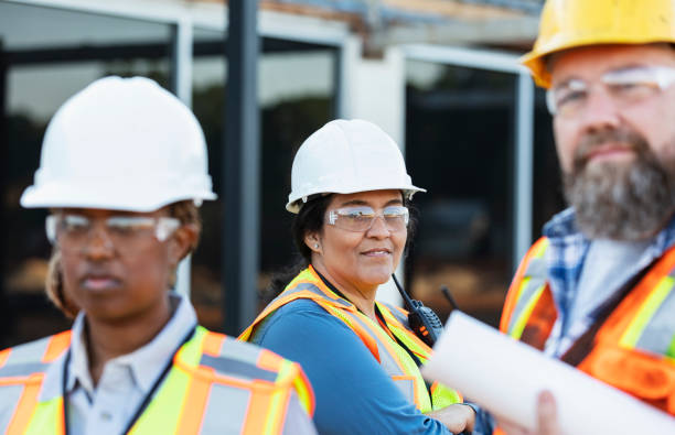 istock Hispanic woman leading group of construction workers 1612926577