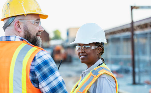 istock African-American woman construction worker with coworker 1612926879