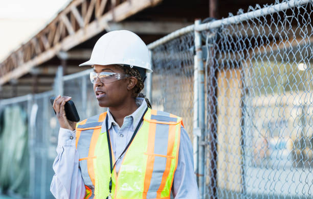 istock Female African-American construction worker on mobile phone 1612927100
