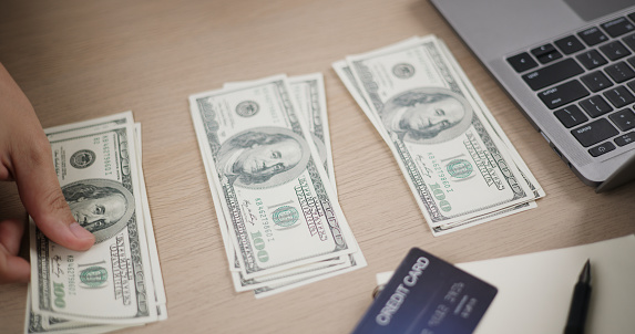 Portrait of Businessman holding banknotes and cash using a laptop. Global network, Investment, Personal loan, Banking and financial concepts.