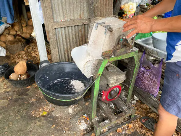 Photo of coconut grated machine in traditional market. This coconut grating machine