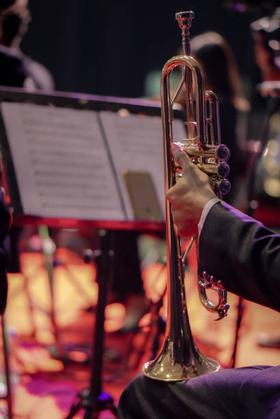 istock Hands playing trumpet orchestra with note sheet on stage. 1613044315