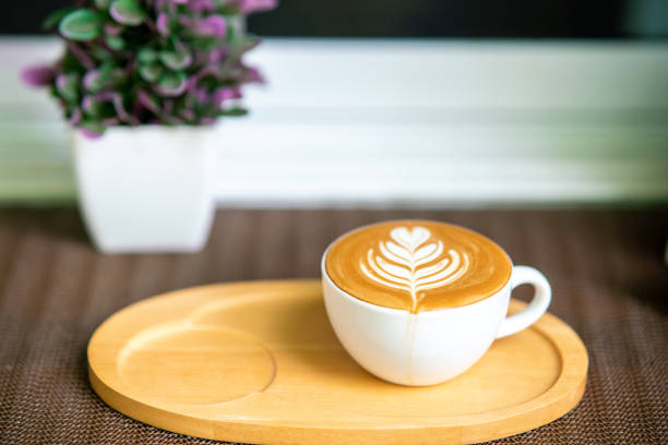 beautiful hot coffee pattern in a white cup on a wooden tray