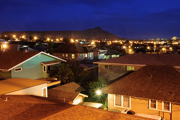 This captivating aerial photograph showcases a villa suburb at night, where the homes are warmly lit from within, offering a sense of comfort and community. The layout of the villas, their yards, and surrounding streets are crisply detailed, thanks to the ambient light. This image serves as an excellent representation of suburban life during the night, making it suitable for projects related to real estate, lifestyle, and community planning.