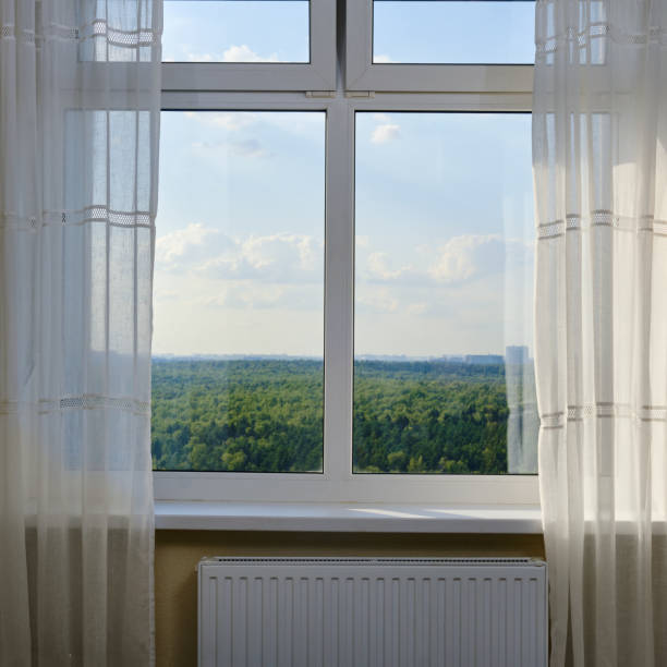 istock Window with curtains overlooking the forest and the sky in the clouds 1613077056