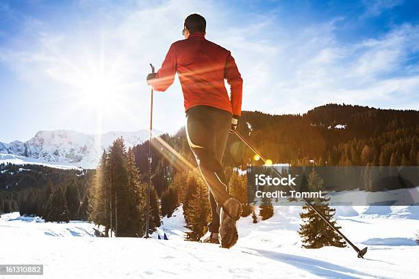 Photo libre de droit de Soleil Brille Sur Un Homme Faire Du Ski De Fond Dans Les Montagnes banque d'images et plus d'images libres de droit de Paire de skis de fond