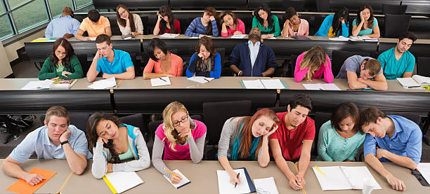 znudzony studentów na biurka podczas snu w sala wykładowa klasie - student sleeping boredom college student zdjęcia i obrazy z banku zdjęć