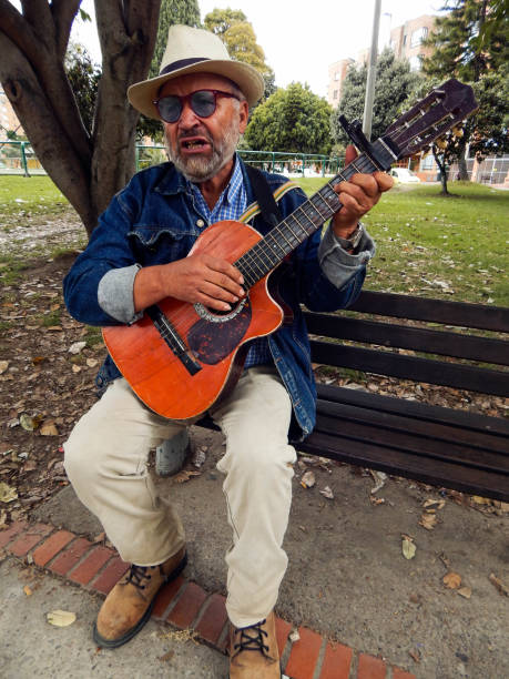 istock senior man playing guitar on park bench 1613166910