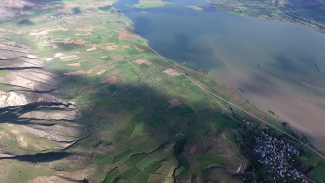 Aerial view of topographic terrestrial geography with treeless hills around the lake