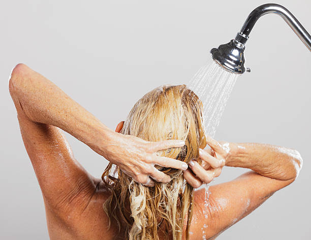 Woman in Shower A mature woman standing in a shower. washing hair stock pictures, royalty-free photos & images