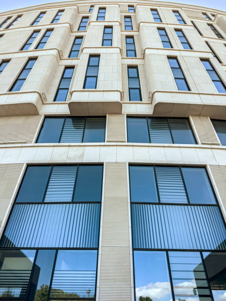 istock new modern office building with blue windows glass. closeup bottom view. 1613265765
