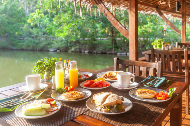 istock Breakfast table near lake in Asian resort. 1613311361