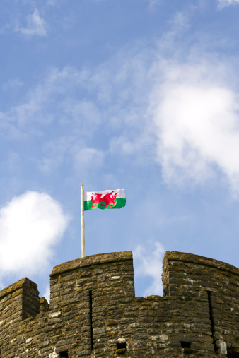 The Red Dragon, the flag of Wales, UK, flying above battlements