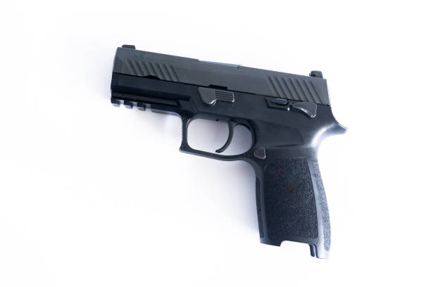 istock Black 9mm pistol lies on a white background. 1613320326