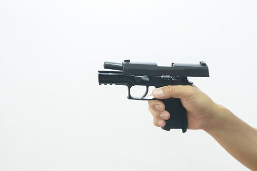 Male hand holding a 9 mm pistol while gripping